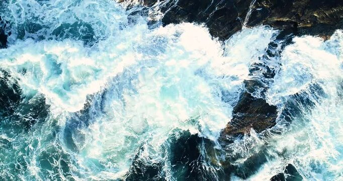Aerial shot of dramatic waves crashing against the sharp, rocky Norwegian coastline.