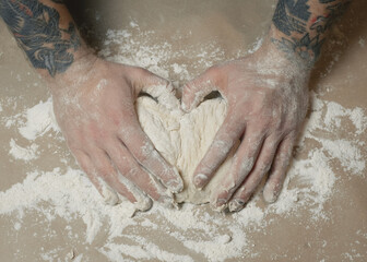 Fototapeta premium Tattooed arms working with dough.