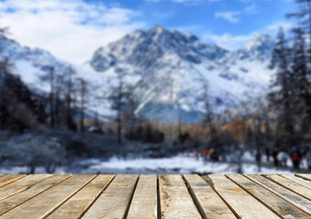 Wooden table top on blurred background mountains and forest nature Snow for important product editing or image layout design. View of the copy space.