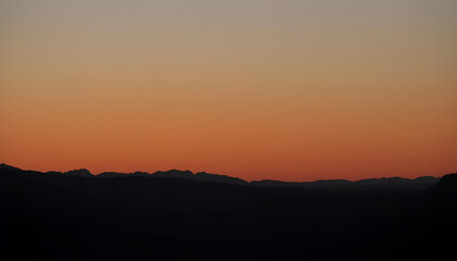 Fototapeta premium Layered mountain silhouettes at dusk, with gradient shadows fading into the horizon, creating depth and a sense of vastness.