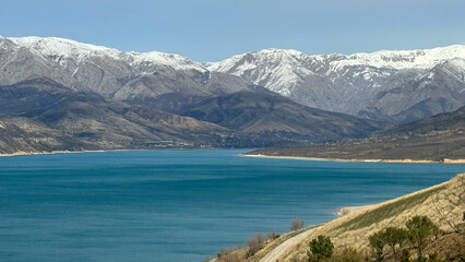 reservoir in the mountains with snowy peaks