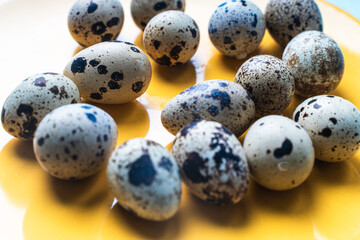 Quail eggs in shell on a yellow plate. The concept of a healthy breakfast.