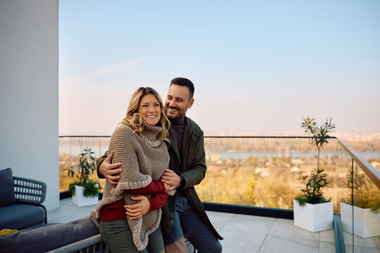 Happy couple enjoying on terrace during autumn day.