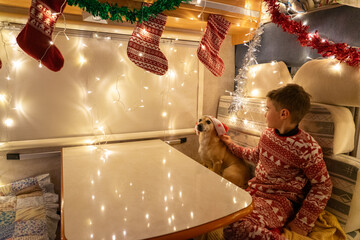 Child celebrating christmas with dog in decorated motorhome