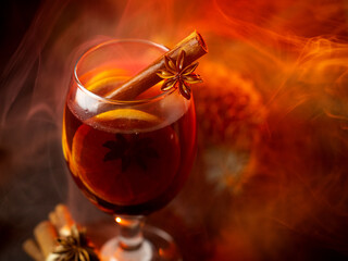 Mulled wine glass with cinnamon stick and anise. Steam from a hot drink