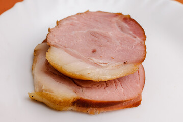 Cold Smoked pork sirloin meat on the white plate. Closeup.