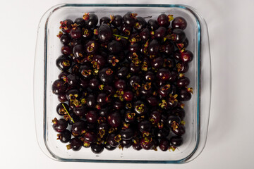 transparent bowl full of Brazilian fruit Grumixama on a white background