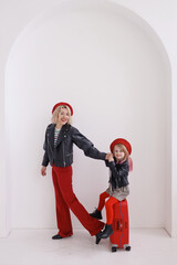 A beautiful woman and a girl in red berets are going to travel