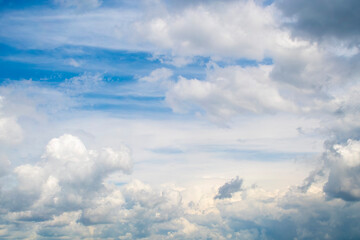 Background with calm blue sky and white cumulus clouds. Relaxing backdrop on the theme of weather and climate.
