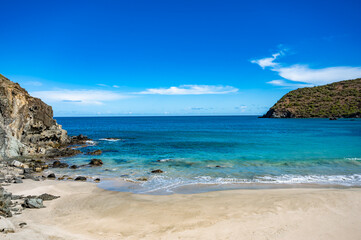 beautiful beach with a blue ocean and a mountain in the background