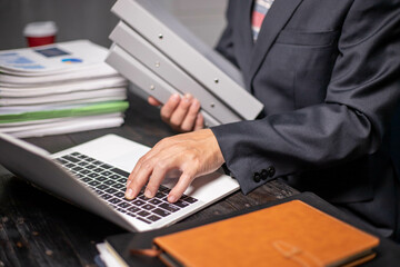 Accountants working on financial investments on calculators, calculating, analyzing business and marketing growth on graphs of various financial documents.