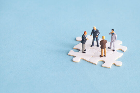 Miniature businessmen collaborate to talk about work and projects