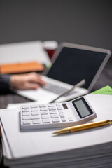 Accountants working on financial investments on calculators, calculating, analyzing business and marketing growth on graphs of various financial documents.