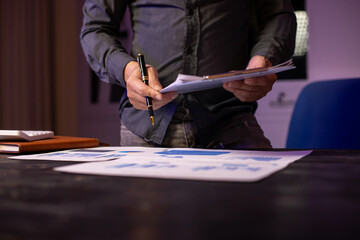 Accountants working on financial investments on calculators, calculating, analyzing business and marketing growth on graphs of various financial documents.