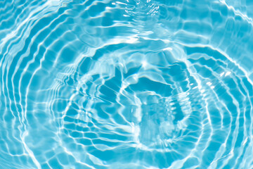 Blue water with ripples on the surface. Defocus blurred transparent blue colored clear calm water surface texture with splashes and bubbles. Water waves with shining pattern texture background.
