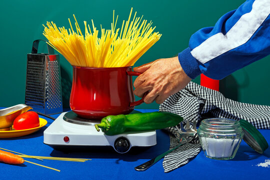 Hand of man holding pot full of spaghetti in studio