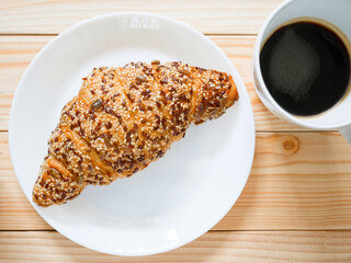 Whole grain croissant and a cup of black coffee