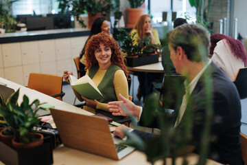 Businesspeople discussing in modern green office with plants