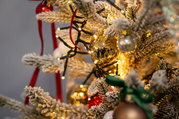 A vibrant red disco ball is beautifully hanging from a christmas tree
