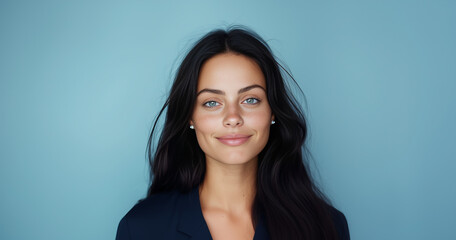 Obraz premium Stunning business woman exuding confidence and charm in a professional setting with a serene blue background
