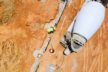 View of foundation preparation at construction site, with concrete mixer truck laying concrete...