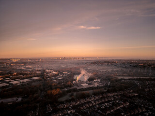 Drone view of Birmingham city at sunrise, highlighting the industrial landscape in the foreground