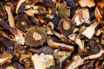 Dried mushrooms, bay boletes and porcini mushrooms spilled on the table. Close-up.