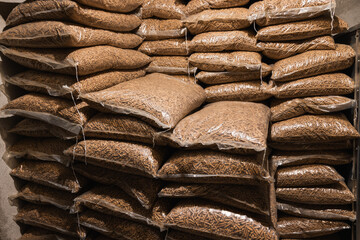 Wood pellets packed in 15 kg bags. Wooden pellets stacked in plastic bags. Heating fuel is delivered to the household to heat interiors in winter. Sustainable future concept.