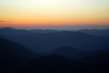 Silhouette of a mountain range with a red sunset in the background