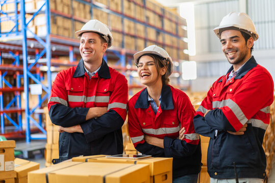 Warehouse team of industrial workers in red uniforms and safety helmets standing smiling teamwork and logistics concept, professional warehouse staff, supply chain, shipping, storage management