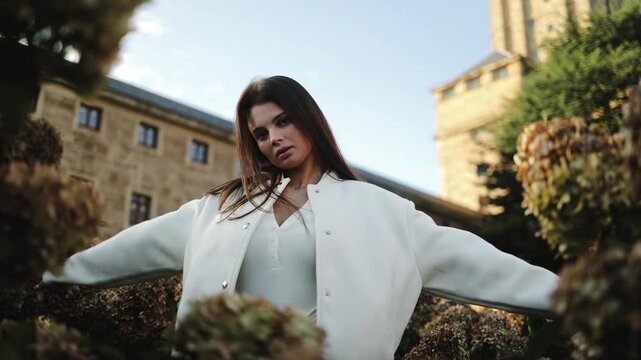 Beautiful woman, student, dancing, posing in the garden, hydrangea bushes against the background of a historical building, university, tourism, education, beauty, spring, fashion, model, perfume