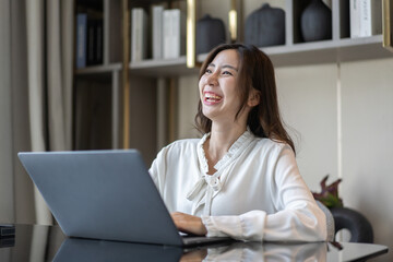 Naklejka premium Young smiling asian woman happy relax use laptop conference work,learning, education, shopping, study online, webinar, online marketing, business, blog, digital internet advertising at home