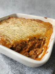 Shepherd's Pie in a White Casserole on a Gray Background