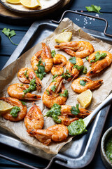  Fried shrimps with lemon and green on a metal tray vertical photo
