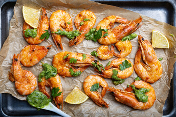  Fried shrimps with lemon and green on a metal tray, top view close up