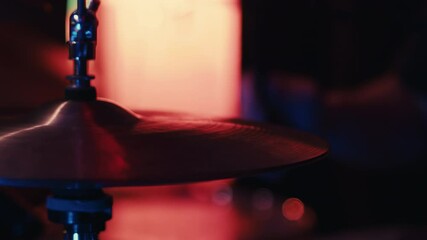 Drummer playing hi-hat cymbals in a nightclub