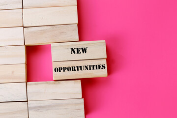 New Opportunities symbol. Concept word New Opportunities on wooden blocks. Beautiful pink...