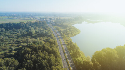 Cars driving on highway by the lake