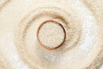 Round bowl with rice on white background with scattered grain. Healthy nutrition and light breakfast.