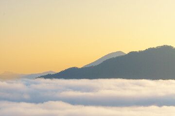 Breathtaking mountain landscape above clouds at sunrise