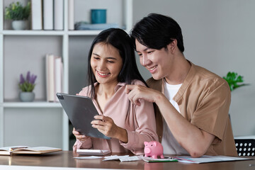 Young Couple Planning Finances Together with Digital Tablet and Piggy Bank for Future Savings and Budget Management in Modern Home Office