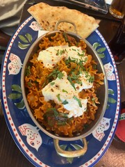 Delicious Italian Pasta Dish with Melted Cheese, Fresh Herbs, and Flatbread on Decorative Plate