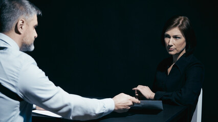 Police detective presents evidence to a female crime suspect during the investigation process