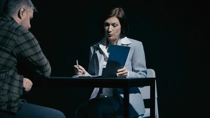 Female detective begins the interrogation of a male suspect, probing him on the crime