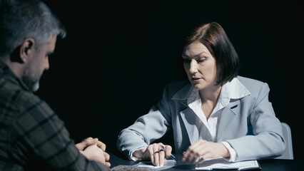 Male suspect rejects the evidence shown to him by a female detective, disputing the proof offered