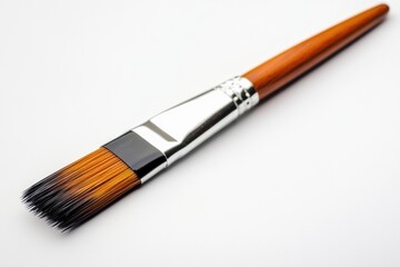 Fototapeta premium A detailed view of a paintbrush lying on a white background, ideal for art-related projects or product photography