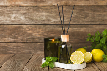 Aromatic reed air freshener on wooden table.Diffuser with natural fruity, floral, spicy aroma.interior scent. Luxury perfume for the home.Orange, lime, coffee, cinnamon, star anise, vanilla and orchid