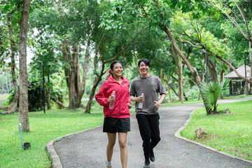 Fototapeta premium Happy Couple Jogging in a Lush Green Park Promoting Health and Wellness Through Outdoor Exercise and Fresh Air