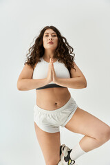 Obraz premium Young plus size woman showcases her confidence in fashionable underwear while practicing yoga.