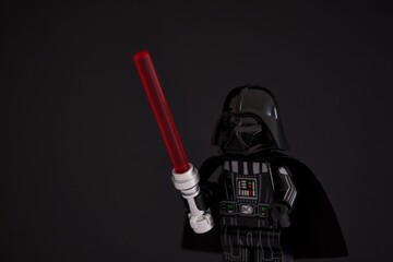 Naklejka premium Tambov, Russian Federation - November 14, 2024 Portrait of Lego Darth Vader minifigure with lightsaber against black background